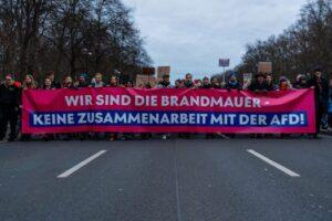 Menschengruppe mit Brandmauer Plakat